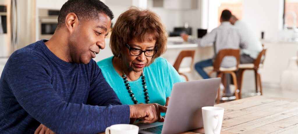 A man and a woman sitting at a computer while researching mesothelioma, asbestos exposure and mesothelioma law firms.