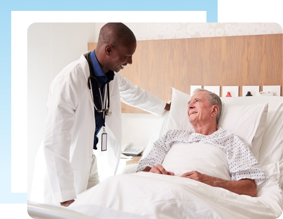 This photo shows a doctor speaking to an older man in a hospital bed. They are discussing his mesothelioma.